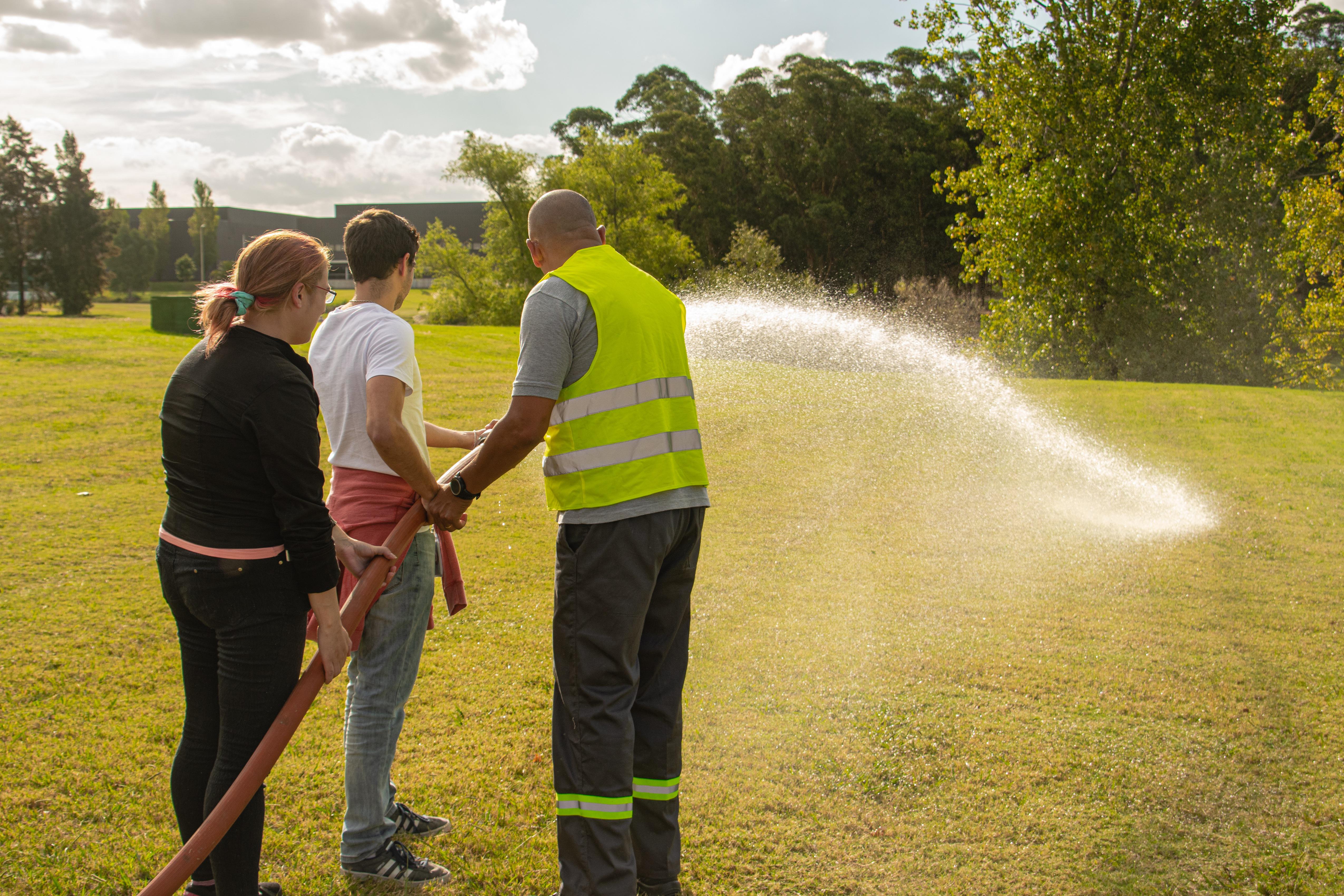 Emergency services trainer running a hose drill